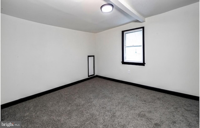 carpeted empty room with beam ceiling