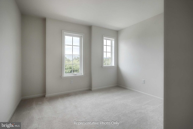 unfurnished room featuring light colored carpet