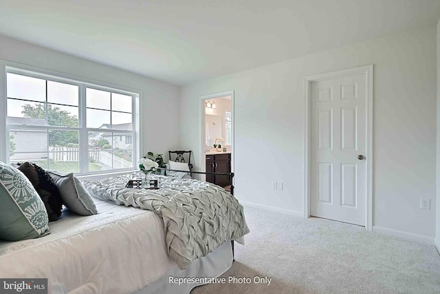 bedroom with light carpet and connected bathroom