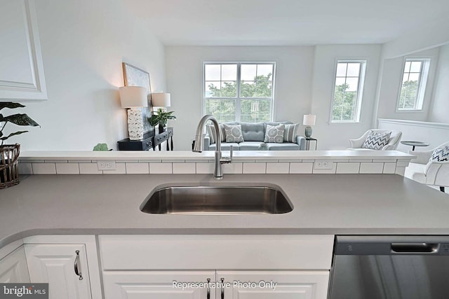 kitchen with dishwasher, white cabinets, plenty of natural light, and sink