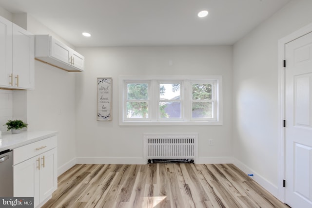 interior space featuring radiator heating unit and light hardwood / wood-style floors