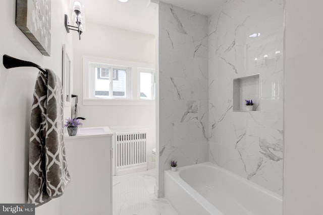 bathroom with tiled shower / bath combo, radiator heating unit, and sink