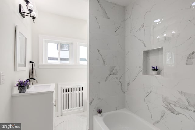 bathroom with radiator, vanity, and tiled shower / bath combo