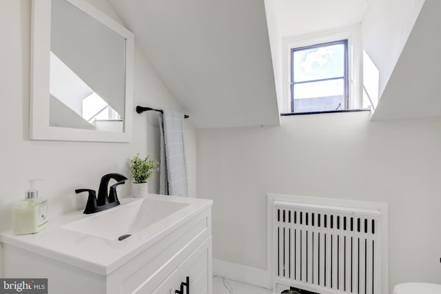 bathroom with vanity, lofted ceiling, and radiator