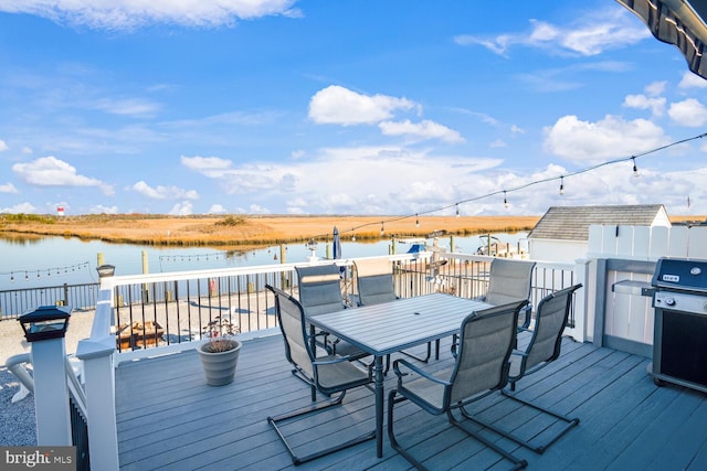 wooden terrace featuring grilling area and a water view