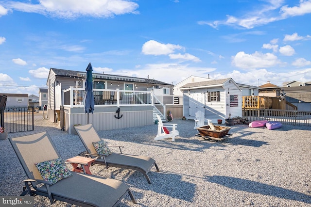 back of property with a wooden deck and a storage unit