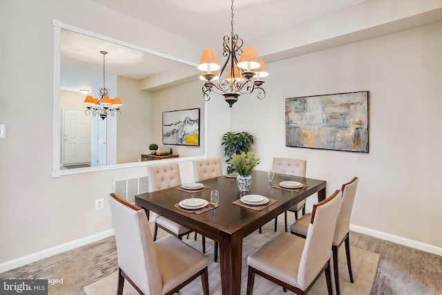 dining space with carpet flooring and a chandelier