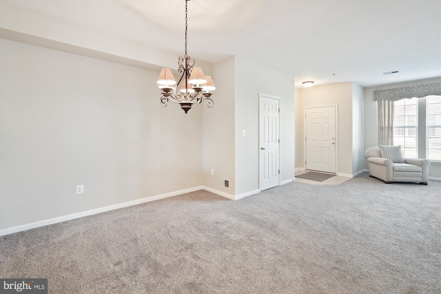 carpeted spare room with a notable chandelier