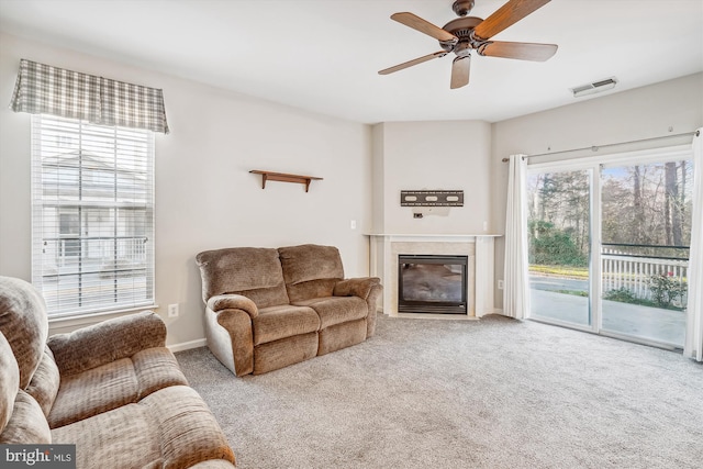 carpeted living room with ceiling fan