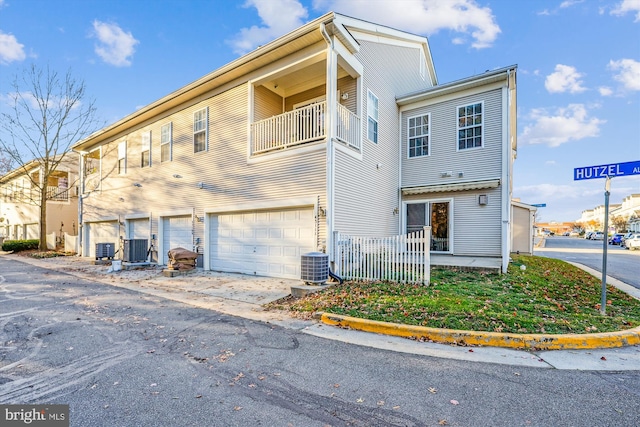 exterior space with a balcony, cooling unit, and a garage