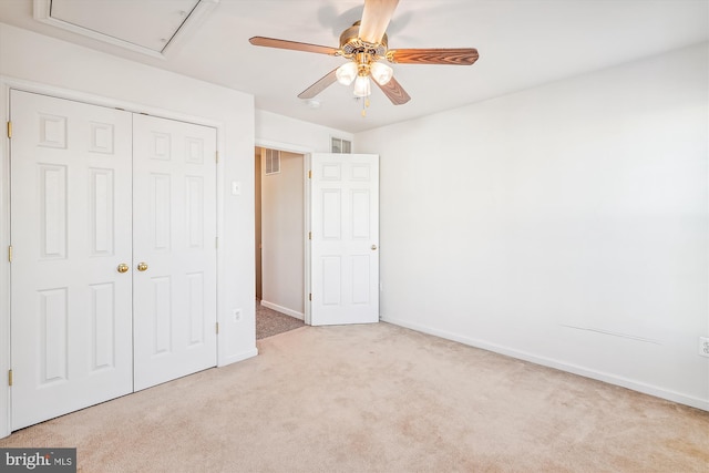 unfurnished bedroom featuring ceiling fan, light carpet, and a closet