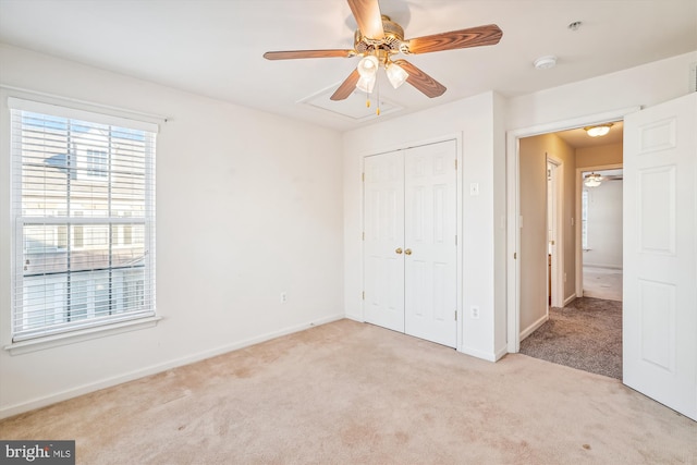 unfurnished bedroom featuring light carpet, a closet, and ceiling fan