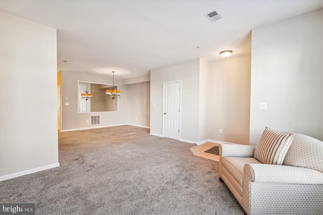 sitting room with carpet and a notable chandelier