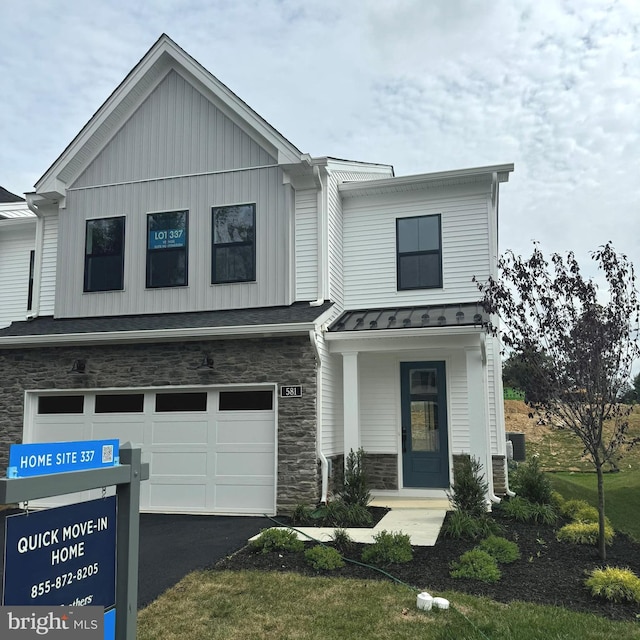 view of front of property featuring a garage, central AC unit, and a front yard