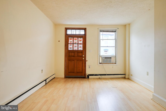 entrance foyer with light hardwood / wood-style flooring, a baseboard radiator, and a textured ceiling