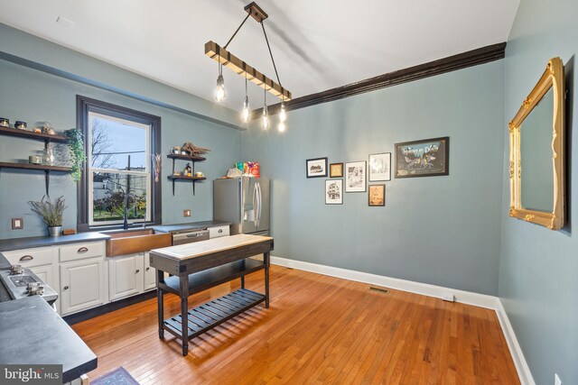 office space with light wood-type flooring, crown molding, and sink