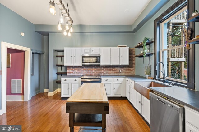 kitchen with white cabinets, stainless steel appliances, and a wealth of natural light