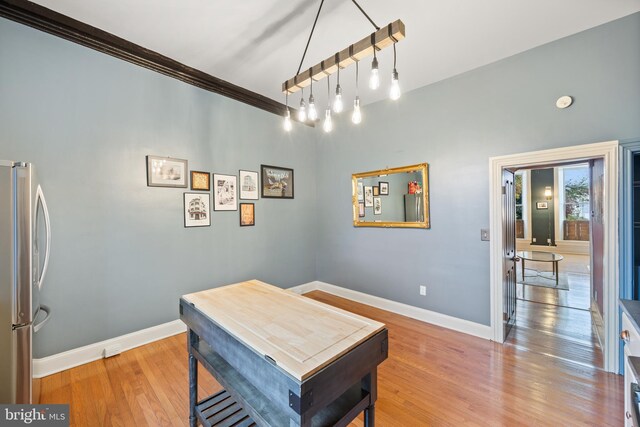 dining space with hardwood / wood-style flooring and ornamental molding