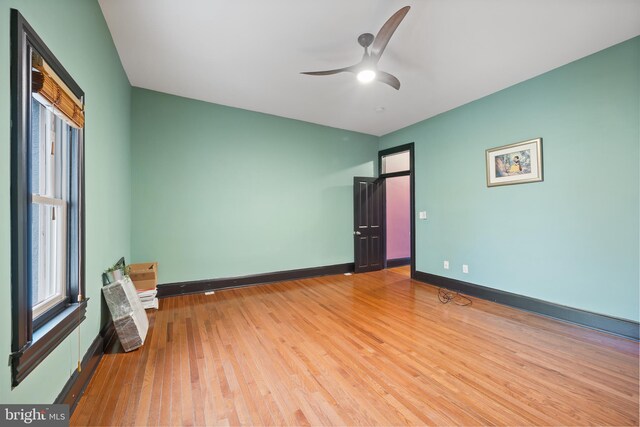 empty room with hardwood / wood-style floors and ceiling fan