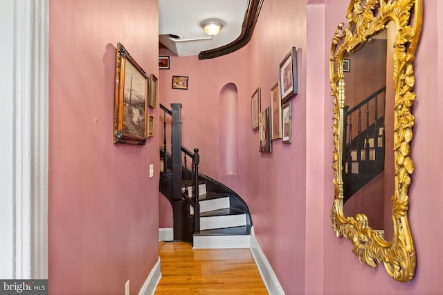 415 E Lafayette Ave, Baltimore, MD 21202 - hallway featuring wood finished floors, baseboards, stairs, and arched walkways
