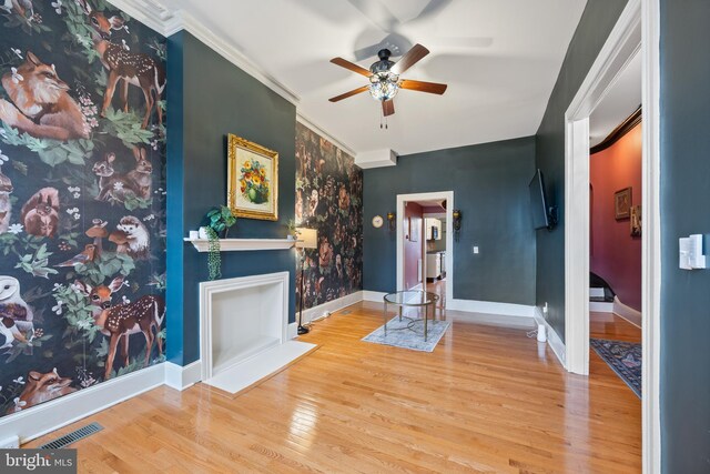 living room featuring light hardwood / wood-style floors, ceiling fan, and ornamental molding