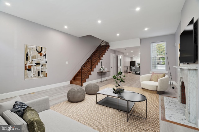 living room featuring a premium fireplace and light hardwood / wood-style flooring