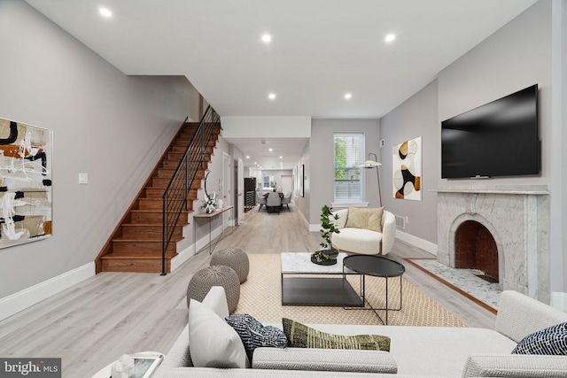 living room with a fireplace and light hardwood / wood-style flooring