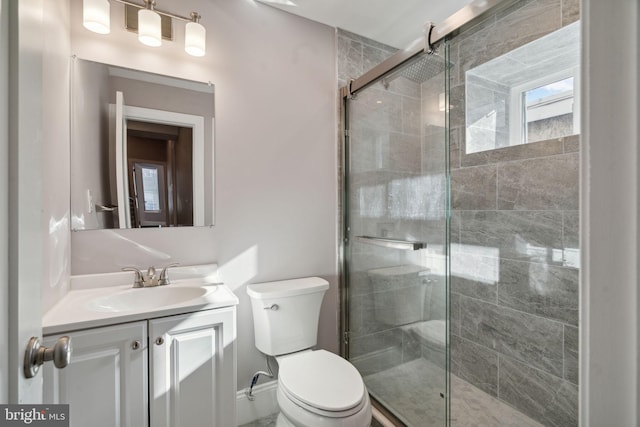 bathroom with vanity, a shower with shower door, and toilet