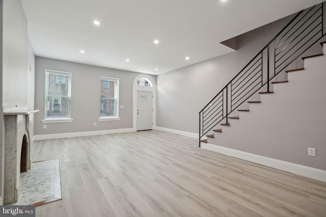 unfurnished living room featuring a fireplace and light hardwood / wood-style floors