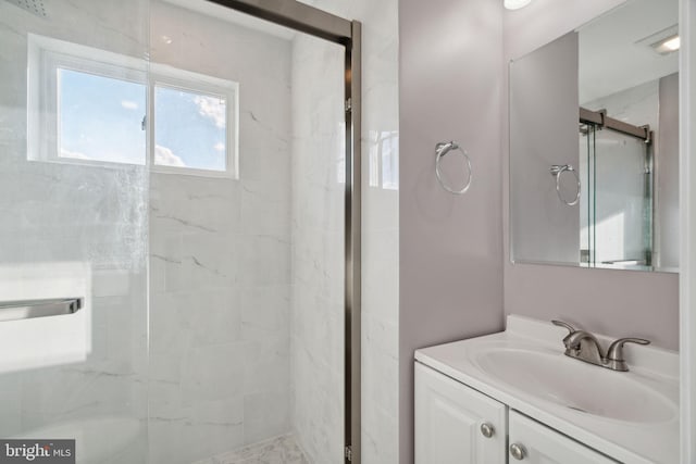 bathroom featuring vanity and a shower with door