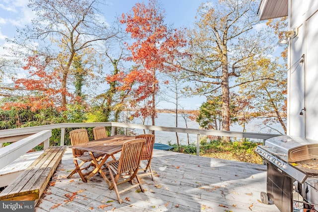 deck with area for grilling and a water view