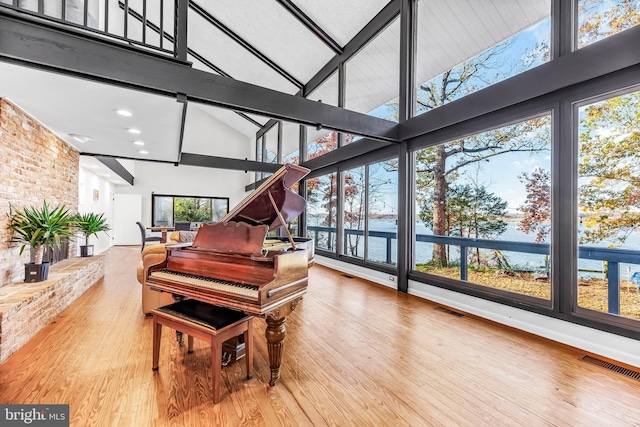 miscellaneous room with beamed ceiling, wood-type flooring, and high vaulted ceiling