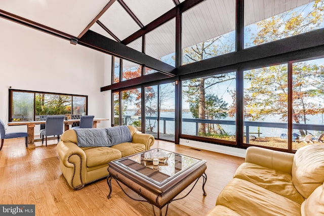 sunroom with a water view and lofted ceiling