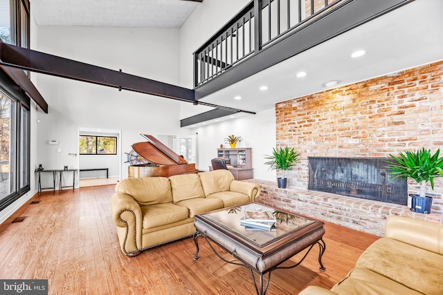 living room featuring a fireplace, hardwood / wood-style floors, and high vaulted ceiling