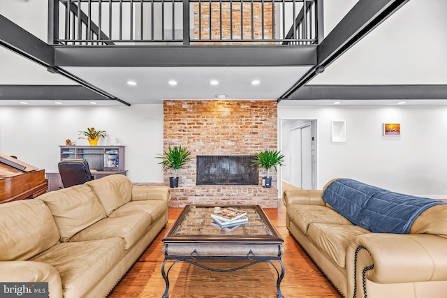 living room with light wood-type flooring and a brick fireplace