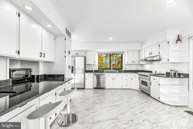 kitchen featuring sink, dark stone countertops, white cabinetry, and stainless steel appliances