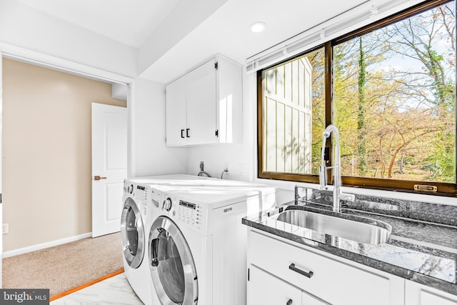 laundry area with washing machine and clothes dryer, plenty of natural light, cabinets, and sink