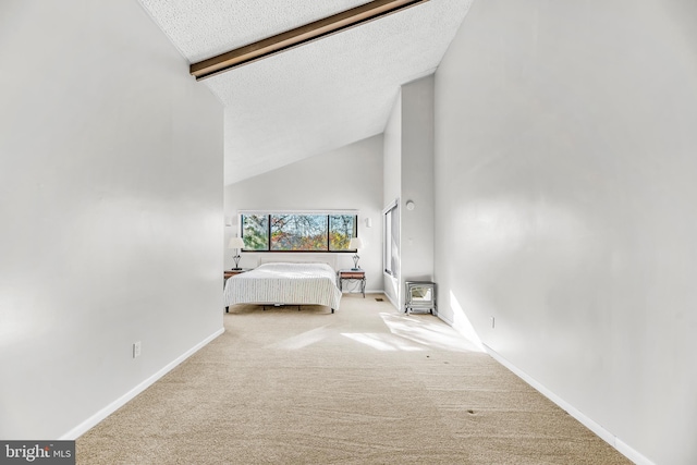 bedroom featuring light carpet, a textured ceiling, and lofted ceiling