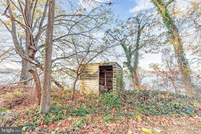 exterior space with a storage unit and a water view