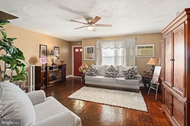 living room with ceiling fan, dark parquet flooring, a textured ceiling, and a wall unit AC