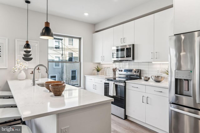 kitchen with white cabinetry, pendant lighting, and appliances with stainless steel finishes