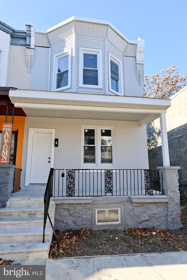 view of exterior entry featuring covered porch