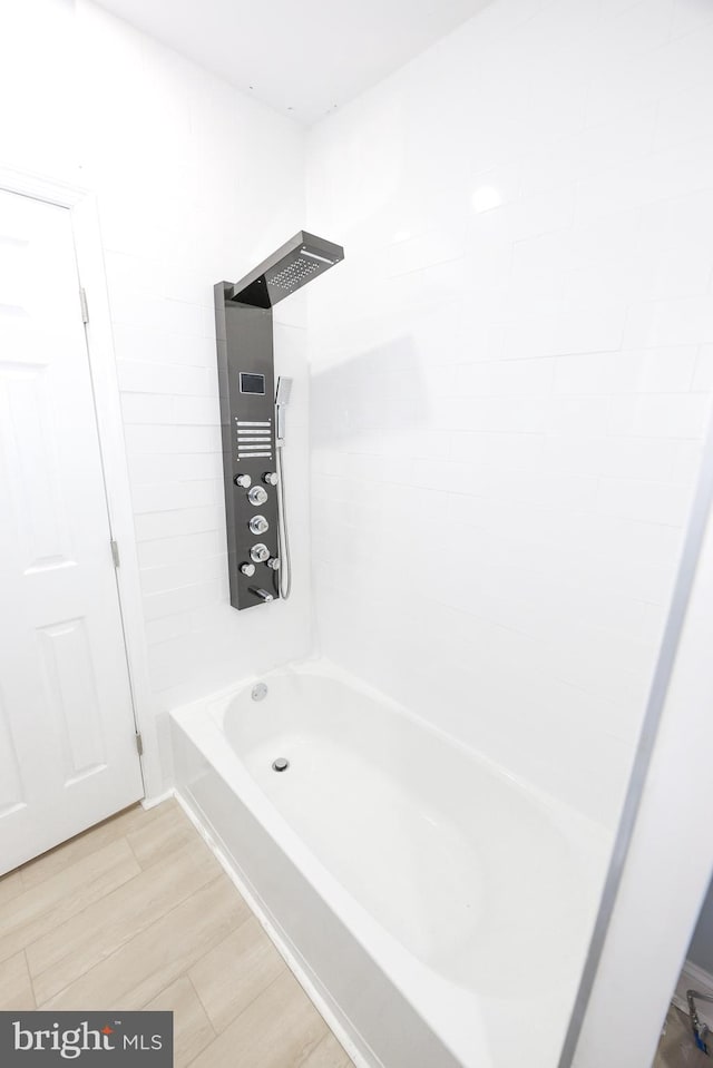 bathroom with tiled shower / bath and wood-type flooring