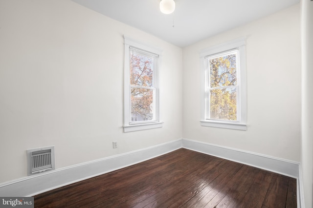 empty room featuring plenty of natural light and hardwood / wood-style flooring