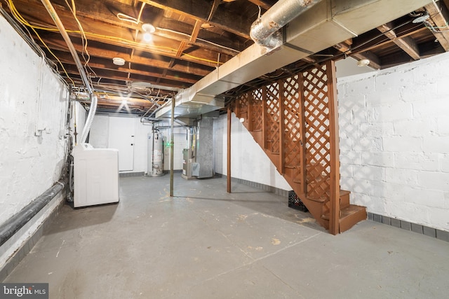 basement with water heater, washer / dryer, and heating unit