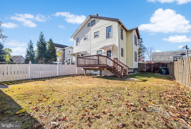 rear view of house featuring a yard and a wooden deck