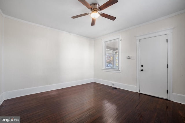 empty room featuring dark wood-type flooring, ornamental molding, and ceiling fan