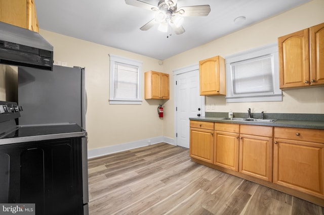 kitchen featuring stove, sink, ceiling fan, extractor fan, and light wood-type flooring