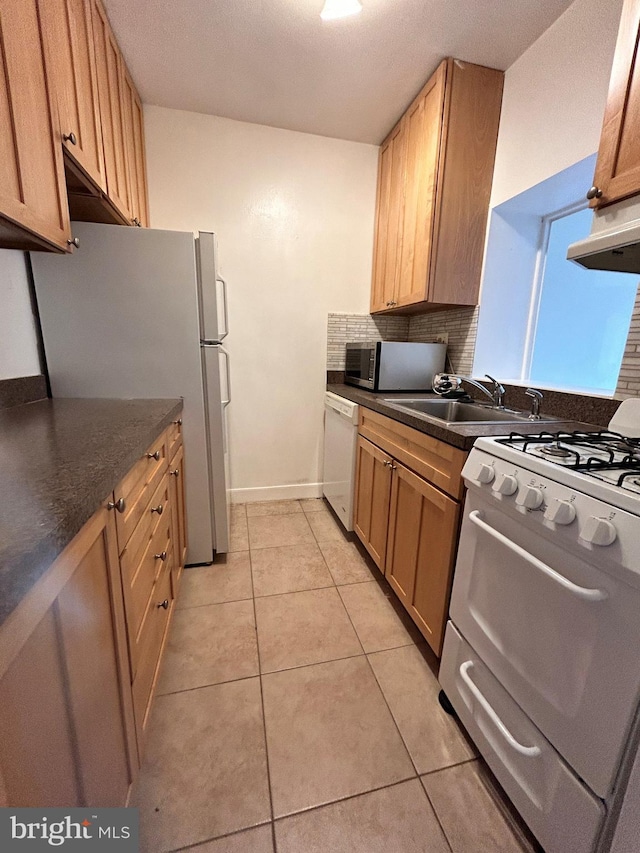 kitchen with light tile patterned floors, white appliances, backsplash, and sink