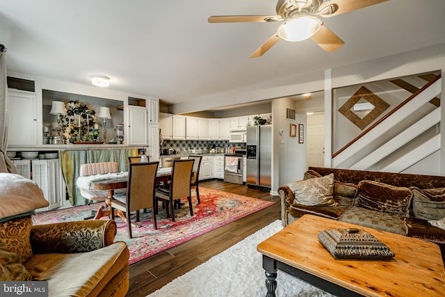 living room featuring ceiling fan and dark hardwood / wood-style flooring